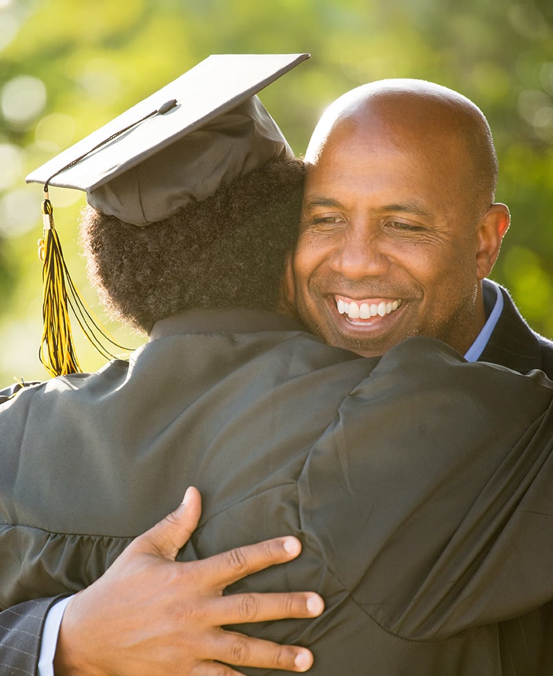 Father hugging his son at his graduation.